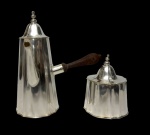 Conjunto composto por bule e açucareiro em metal espessurado a prata, ambos com corpo facetado e tampas encimadas por pináculos torneados. Bule com bico vertedor e cabo em madeira torneada. Medidas: bule 19 x 13,5 x 20,5 cm; açucareiro 12 x 9,5 cm.