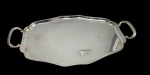 Meridional  Grande e imponente bandeja em metal espessurado a prata, de formato retangular com cantos suavemente recortados, borda contornada por delicado filete e alças laterais vazadas. Medidas: 54,5 x 31 cm.