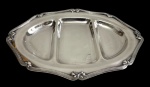 Fracalanza  Petisqueira em metal espessurado a prata, de formato ovalado com três divisões, borda contornada por delicado filete e extremidades facetadas. Manufatura marcada na base. Medidas: 38 x 26 cm.
