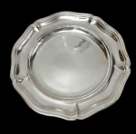 Imponente bandeja em metal espessurado a prata, de formato circular, com centro liso e borda recortada de contorno moldurado. Marca da manufatura gravada. Medidas: 4 x 38 cm.
