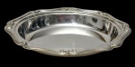 Fracalanza. Antiga travessa funda em metal espessurado a prata, de formato oval, com borda recortada ornamentada por frisos em relevo e alças integradas. Medidas: 4 x 28 x 22,5 cm.