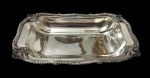 Meridional Sheffield. Antiga travessa funda em metal espessurado a prata, de formato retangular com cantos arredondados, borda cinzelada com volutas e motivos vegetalistas de inspiração Rococó, centro liso. Medidas: 20 x 31,5 cm.