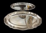 Duas bandejas em metal espessurado a prata, de formato oval, com bordas recortadas de inspiração Luís XV e centro liso. Apresentam desgaste no banho de prata. Medidas: 2,5 x 44,5 x 30 cm.