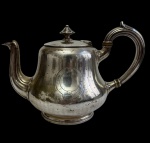 CHRISTOFLE - Antigo e raro bule para chá em metal prateado, de renomada manufatura francesa, com corpo de linhas bojudas, decoração em delicado cinzelado pontilhado e cartela frontal lisa para monograma. Tampa articulada com pegador torneado e bico recurvo. Apresenta marcas do tempo. Medidas: 25,5 x 18 x 16 cm.