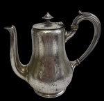 CHRISTOFLE - Antigo e raro bule para café em metal prateado, de renomada manufatura francesa, com corpo de linhas elegantes, decoração em delicado cinzelado pontilhado e cartela frontal lisa para monograma. Tampa articulada com pegador torneado, bico alongado e alça curva. Apresenta marcas do tempo. Medidas: 21 x 19 x 12 cm.