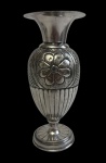 Antigo vaso em metal espessurado a prata, com corpo em formato de ânfora, decorado em relevo com motivos florais e geométricos, base circular. Apresenta marcas do tempo. Medidas: 15,5 x 7 cm.