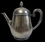 Antigo bule para chá em metal espessurado a prata, marcado na base, com corpo em formato balaústre, decoração em cinzelado pontilhado, cartela central monogramada, bico e alça com frisos em relevo e tampa de encaixe com pomo torneado. Apresenta marcas do tempo. Medidas: 17,5 x 21,5 x 11,5 cm.