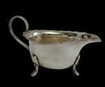 Antiga molheira em metal espessurado a prata, manufatura inglesa (England), com corpo liso, bico vertedor alongado, alça arqueada e três pés de apoio. Medidas: 8 x 14 x 7,5 cm.