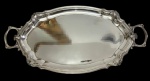 WMF  Antiga bandeja oval em metal espessurado a prata, de renomada manufatura alemã, com borda recortada em relevo de inspiração rococó e elegantes alças vazadas integradas ao corpo da peça. Manufatura gravada na base. Medidas: 2,5 x 62 x 32 cm.