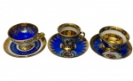 Luiz XV. três xícaras para café com seus respectivos pires em porcelana esmaltada, decoradas em azul cobalto e branco, com reservas florais policromadas e rica ornamentação em ouro. Manufatura marcada no verso. Um pires apresenta restauro.