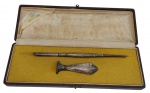 PRATA. Antigo conjunto de escrita em estojo, composto por caneta de aparo (pena) e sinete para selo de cera, ambos com cabos em prata ricamente ornamentados em relevo. Acompanha estojo original. Peso total das peças: 14 g. Medidas do estojo: 3 x 23 x 8 cm.