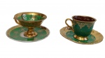 Conjunto com 2 xícaras para café em porcelana Luís XV, ornamentadas com rica decoração em verde e frisos em ouro, ambas apoiadas sobre pés elevados. Interior parcialmente dourado.