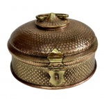 Antiga caixa de latão indiana, ricamente gravada e ornamentada em relevo, com tampa abaulada, alça móvel e fecho frontal, apresentando delicado trabalho artesanal em toda a superfície. Medidas: 17 x 24,5 cm.