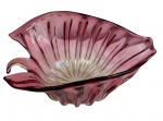 Antigo e imponente centro de mesa em vidro de Murano, na tonalidade rosa, com corpo modelado em forma de folha, ornamentado por delicadas caneluras em relevo e bordas onduladas, apresentando elegante movimento orgânico característico da manufatura italiana. Medidas: 16 x 38,5 x 25 cm