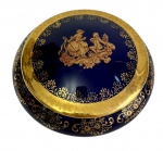Limoges, France. Antiga caixa com tampa em porcelana, na tonalidade azul-cobalto, ricamente ornamentada com frisos em ouro e cena galante em reserva central. Manufatura no verso. Medidas: 5 x 11 cm.