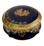 Limoges, France. Antiga caixa com tampa em porcelana, na tonalidade azul-cobalto, ricamente ornamentada com frisos em ouro e cena galante em reserva central. Manufatura no verso. Medidas: 5,5 x 11,5 cm.