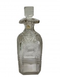 Antiga garrafa em cristal lapidado, de corpo facetado e ornamentado por rica lapidação geométrica, com tampa original. Apresenta discreto trincado na tampa. Medidas: 20,5 x 7,5 cm.
