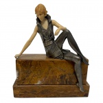 Escultura Art Déco em bronze e baquelite, representando jovem elegante em repouso, sobre base em mármore. Medidas: 19 x 8,5 x 22,5 cm.