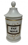 Antigo frasco de farmácia em porcelana, com tampa, decoração em dourado e cartela identificada "EXT: SENNAE". Apresenta restauros na tampa. Medidas: 26,5 x 11,5 cm.