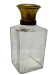 Antigo perfumeiro em cristal, de formato retangular com corpo facetado e tampa em metal dourado. Medidas: 12,5 x 6 x 6 cm.