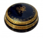 Limoges, France. Antiga caixa com tampa em porcelana, na tonalidade azul-cobalto, ricamente ornamentada com frisos em ouro e cena galante em reserva central. Manufatura no verso. Medidas: 5 x 11,5 cm.