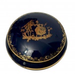 Limoges, France. Antiga caixa com tampa em porcelana, na tonalidade azul-cobalto, ricamente ornamentada com frisos em ouro e cena galante em reserva central. Manufatura no verso. Medidas: 5 x 13 cm.