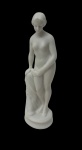 Pequena escultura em biscuit, representando figura feminina seminua em pé, apoiada sobre base circular, com delicado acabamento. Medidas: 12 cm