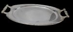 Bandeja em metal espessurado a prata, de formato ovalado com extremidades facetadas, borda contornada por delicado filete e alças laterais vazadas de desenho clássico. Medidas: 54 x 30 cm.