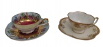 Duas xícaras para café com seus respectivos pires, em porcelana japonesa, ricamente decoradas com cenas galantes e motivos florais policromados, com ampla ornamentação em ouro. Uma das peças apresenta fundo azul-claro com reservas figurativas e centro em tom vinho, e a outra decoração floral com detalhes dourados. Manufaturas no verso.