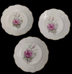 Vista Alegre, Portugal. Três pratos para sobremesa em porcelana, decorados com composição floral policromada no centro, bordas em relevo e filetadas a ouro. Manufatura no verso. Medidas: 20 cm de diâmetro cada.