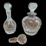Três peças em cristal, sendo dois frascos para perfume e uma tampa avulsa lapidada. Frascos com decoração gravada e lapidada, um deles com gargalo guarnecido em prata. Observação: o frasco com gargalo em prata apresenta trincados no gargalo, conforme fotos. Medidas: 17 x 11 cm; 17 x 6 cm. Tampa avulsa: 8 cm de diâmetro.