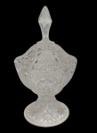 Antiga compoteira em cristal translúcido, com corpo ricamente lapidado em padrões geométricos e estrelados, bordas recortadas, tampa com pega em formato de pináculo e base elevada igualmente lapidada. Medidas: 28 x 15 cm.