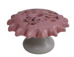 Paliteiro em opalina nas tonalidades rosa e branca, com borda ondulada e decoração floral policromada aplicada na parte superior. Medidas: 6 x 10,5 cm.