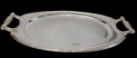 Bandeja em metal espessurado a prata, de formato ovalado com extremidades facetadas, borda contornada por delicado filete e alças laterais vazadas de desenho clássico. Medidas: 54 x 30 cm.