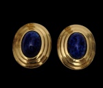 Christian Dior. Par de brincos de pressão em metal dourado, com aplicação central oval em resina na tonalidade azul-cobalto. Assinados no verso, com fecho de pressão original da marca.