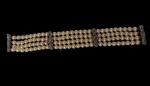 Bracelete com quatro fileiras de pérolas verdadeira, entremeios e fecho em prata paládio trabalhado, ornamentados com motivos florais. Comprimento: 19 cm.
