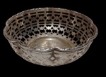 Bowl em metal espessurado a prata, marcado na base, com corpo vazado em padrão geométrico e borda recortada. Medidas: 4 x 12,5 cm