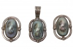 Conjunto em prata, composto por par de brincos e pingente, ornamentados por grandes pérolas barrocas em tonalidade cinza com iridescência natural, montadas em aro oval de linhas clássicas. Peso total: 30 g. Medidas: brincos 3,5 x 2,6 cm; pingente 5,2 x 2,5 cm.