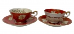 Wako China. Duas xícaras de coleção para café em porcelana esmaltada e vitrificada, acompanhadas de seus respectivos pires. Decoração floral em reservas sobre fundo vermelho, rica ornamentação em dourado e acabamento filetado a ouro. Manufatura no verso.