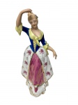 Imponente escultura em porcelana policromada representando dama em traje de inspiração Rococó, com vestes ornamentadas por decoração floral e detalhes em douração, sobre base moldurada. Apresenta perda em um dos dedos da mão. Medidas: 29 x 10 x 11,5 cm.