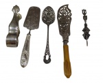 Cinco utensílios de servir em metal espessurado a prata, composto por pegador para torrões de açúcar, espátula para torta gravada, colher de servir com bojo em relevo, espátula vazada para servir com cabo em baquelite e pequeno pegador. Medidas: 31,5 / 26 / 23 / 15,5 / 15 cm.