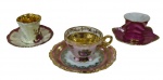 Três xícaras para café de coleção em porcelana, de manufaturas e modelos distintos, ricamente decoradas com reservas florais, acabamento esmaltado e detalhes em douração.