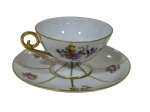 Xícara para chá de coleção com seu respectivo pires em porcelana, decorada com reservas florais em policromia, frisos e detalhes em douração. Marca da manufatura na base. Medidas: 6 x 14 cm.