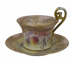 Limoges, França. Antiga xícara de coleção para chá com seu respectivo pires em porcelana, ricamente decorada com reservas florais em policromia, ornamentação em ouro e alça de desenho vazado. Marcas da manufatura na base.