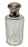 Antigo perfumeiro / frasco de colônia de época vitoriana/eduardiana em cristal translúcido facetado, apresentado com a tampa de encaixe em prata de lei removida, revelando o gargalo interno revestido e a rara rolha interna original de vidro fosco lapidado para vedação do perfume, mantendo o acabamento em cordão perolado na tampa polida. Medidas: 10,5 cm.
