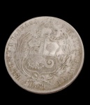 Peru. Moeda de 1 Sol, 1869, em prata, apresentando no anverso a alegoria da Liberdade sentada, acompanhada da inscrição "Firme y Feliz por la Unión", e, no reverso, o brasão nacional da República do Peru envolto por ramos de louros. Peso: 24,8 g. Medidas: 3,7 cm de diâmetro.