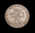 México. Moeda comemorativa de 25 Pesos, Jogos da XIX Olimpíada, México 1968, em prata, apresentando no anverso representação de atleta inspirada na arte pré-colombiana, acompanhada da inscrição "Juegos de la XIX Olimpiada México 1968" e dos anéis olímpicos. No reverso, brasão nacional dos Estados Unidos Mexicanos, com a águia sobre o cacto devorando a serpente, valor facial e legenda nacional. Peso: 22,5 g. Medidas: 3,8 cm de diâmetro.