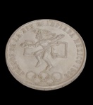 México. Moeda comemorativa de 25 Pesos, Jogos da XIX Olimpíada, México 1968, em prata, apresentando no anverso representação de atleta inspirada na arte pré-colombiana, acompanhada da inscrição "Juegos de la XIX Olimpiada México 1968" e dos anéis olímpicos. No reverso, brasão nacional dos Estados Unidos Mexicanos, com a águia sobre o cacto devorando a serpente, valor facial e legenda nacional. Peso: 22,5 g. Medidas: 3,8 cm de diâmetro.