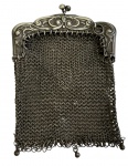 Antigo porta-níquel em prata, confeccionado em malha de elos entrelaçados, com armação ricamente ornamentada em relevos de volutas e fecho de pressão tipo kiss-lock. Peça de coleção, característica do final do século XIX e início do século XX. Peso: 30,6 gramas. Medidas: 9,5 x 6,5 cm.