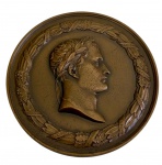Antiga medalha em bronze, apresentando no anverso o busto laureado de Napoleão Bonaparte em alto-relevo, circundado por coroa de louros. No reverso, representação da Ilha de Santa Helena, com a inscrição "Il mourut sur un rocher - Île Ste. Hélène - 5 Mai 1821", alusiva ao falecimento de Napoleão. Peso: 141,9 gramas. Medidas: 6,8 x 0,5 cm